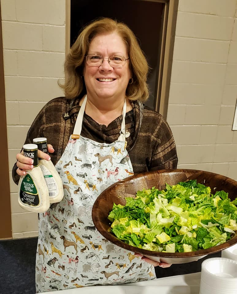 Sharon Carson serving salad at a community supper