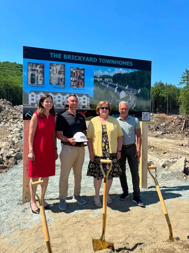 Sharon Carson with developers and local officials in front of a Brickyard Townhomes project sign