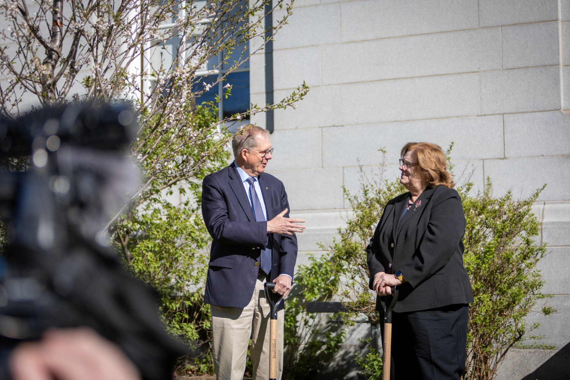 Sharon Carson speaking with a colleague at an outdoor groundbreaking event